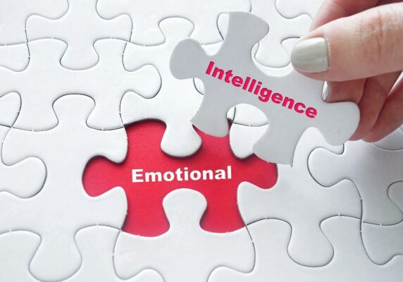 white puzzle pieces over a red background with one white piece having Intelligence written on it and the red space where it goes stating Emotional