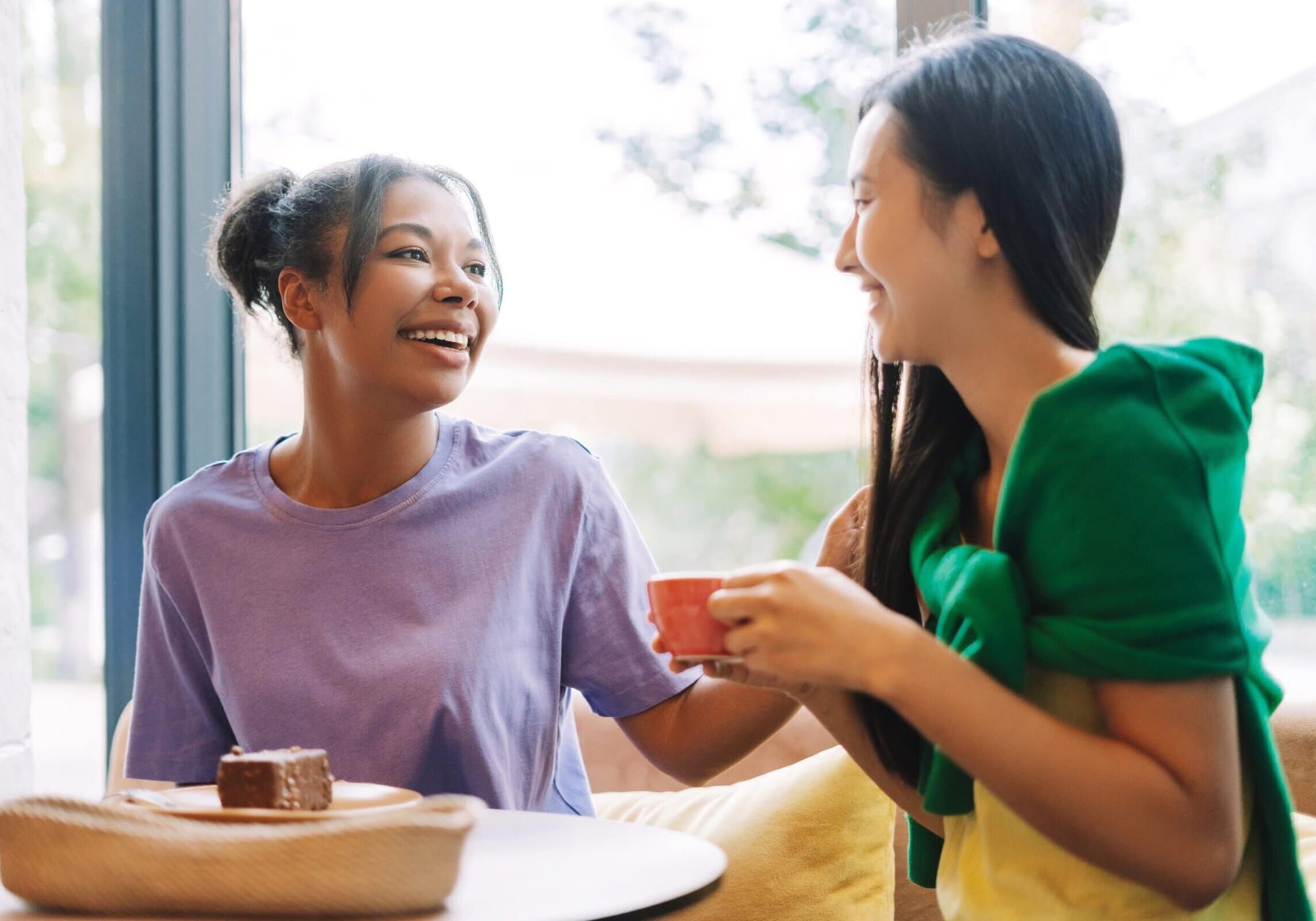 Two,Friends,Enjoying,Coffee,And,Cake,At,A,Cozy,Cafe,