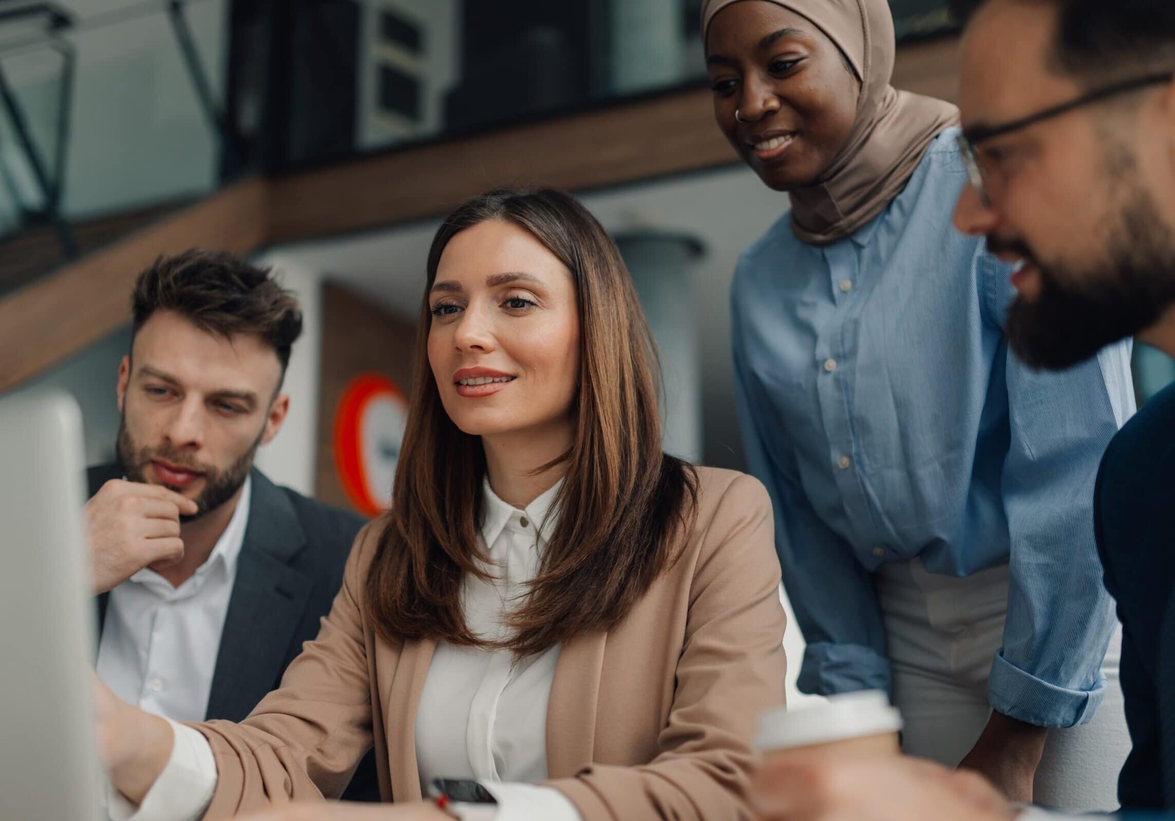 Four,Diverse,Businesspeople,Collaborating,On,A,Project,,Looking,At,A