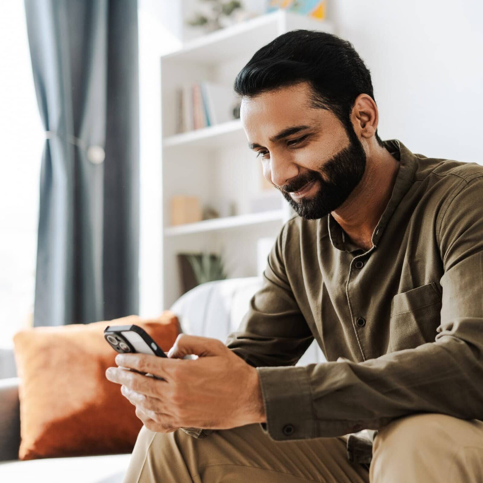 Happy,,Smiling,Indian,Man,Holding,Mobile,Phone,,Using,Mobile,App