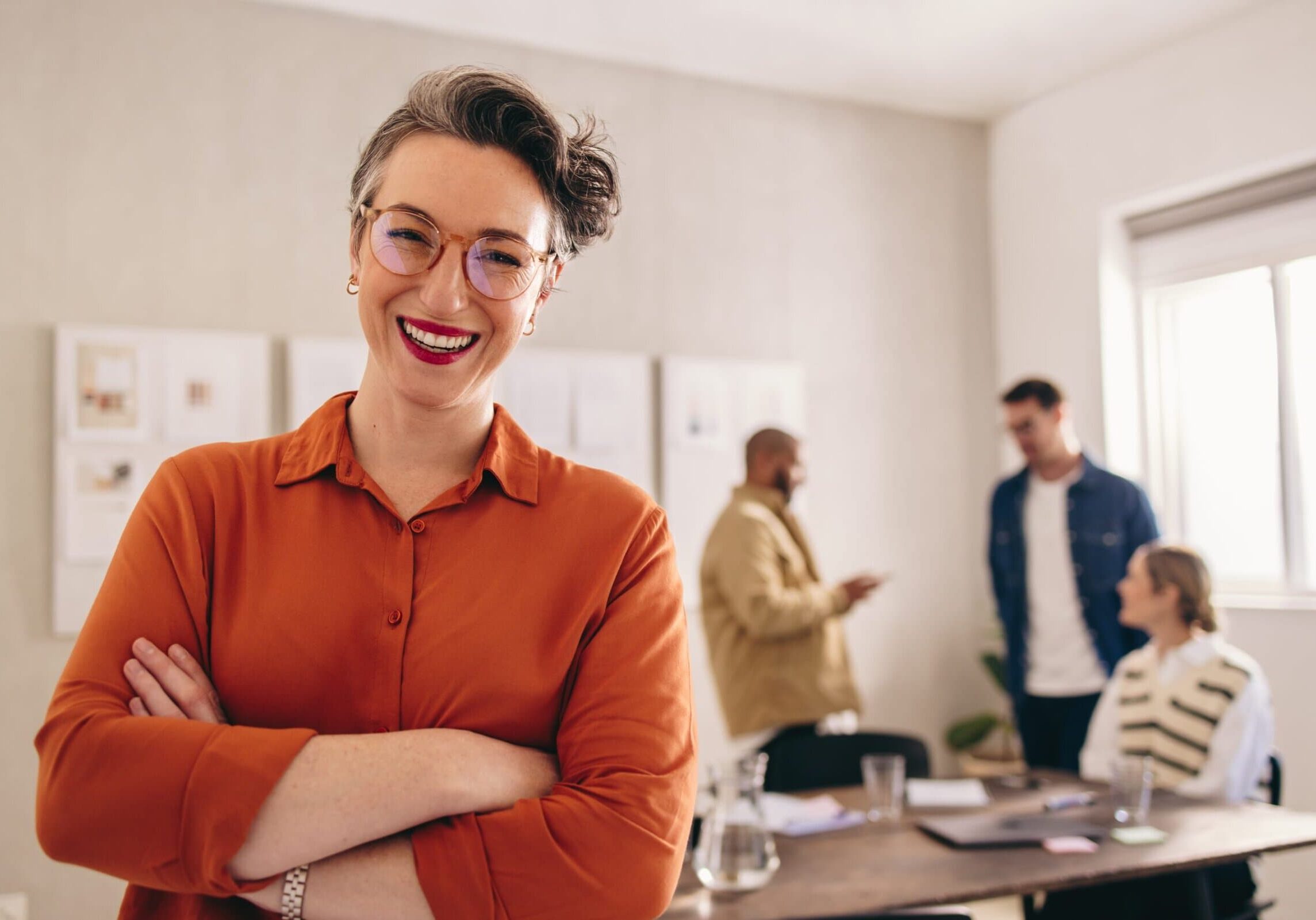 Cheerful,Businesswoman,Smiling,At,The,Camera,While,Standing,In,An