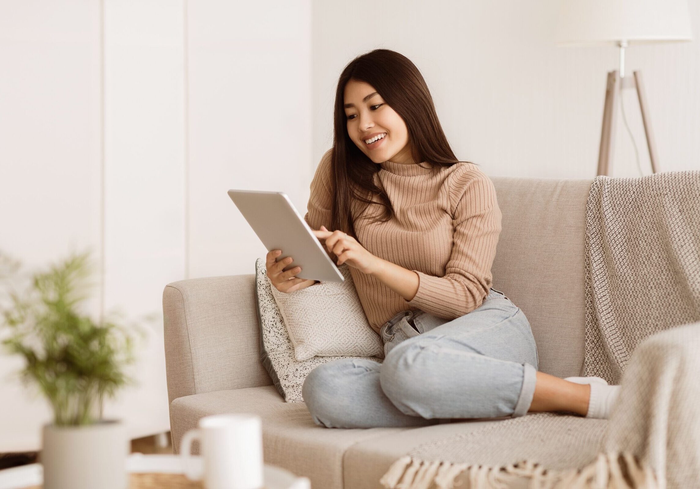 A,Woman,Sits,On,A,Couch,At,Home,,Using,A
