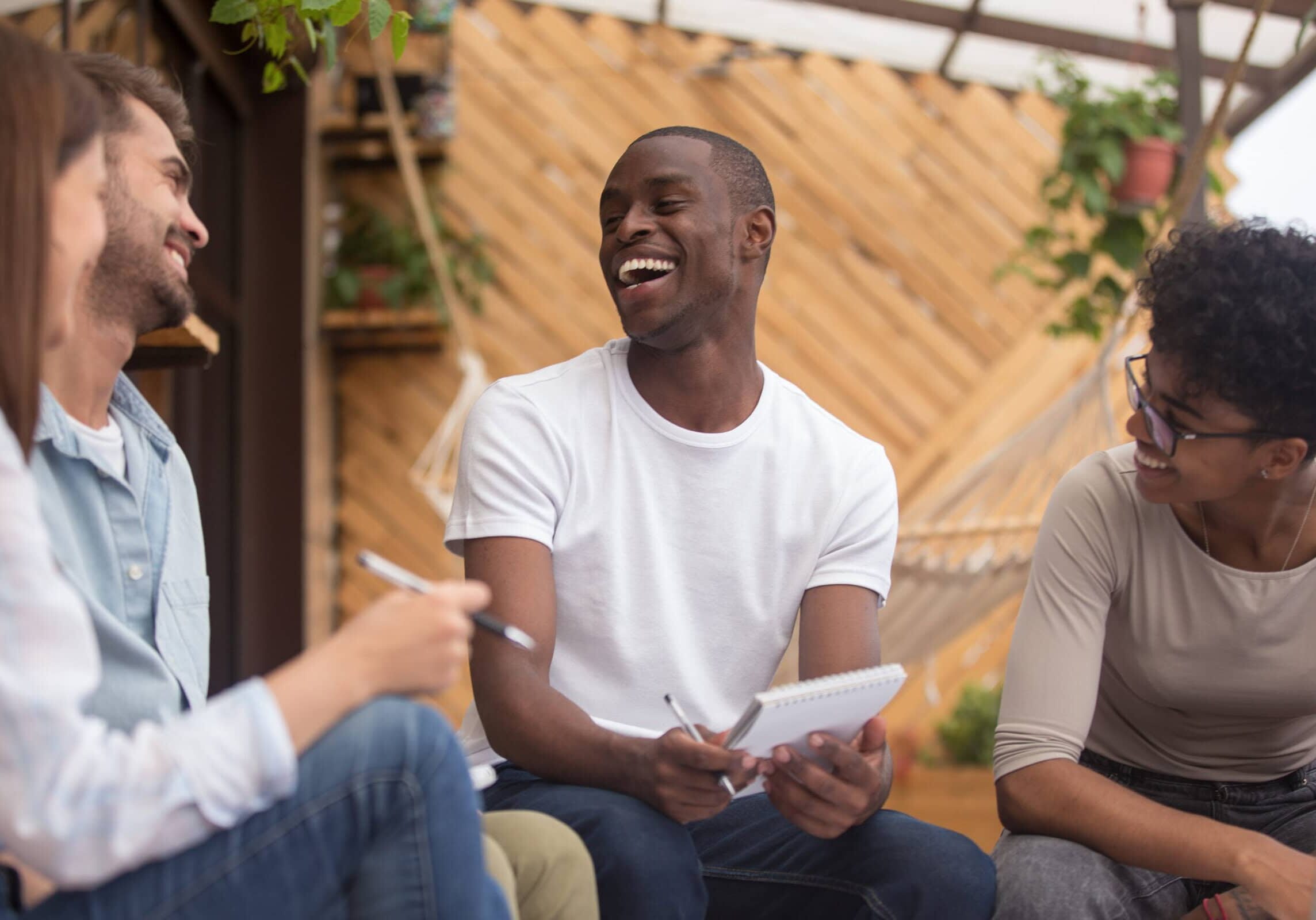 Multiracial,Happy,Friends,Laughing,Joking,Studying,Together,With,Notebooks,Outdoor,