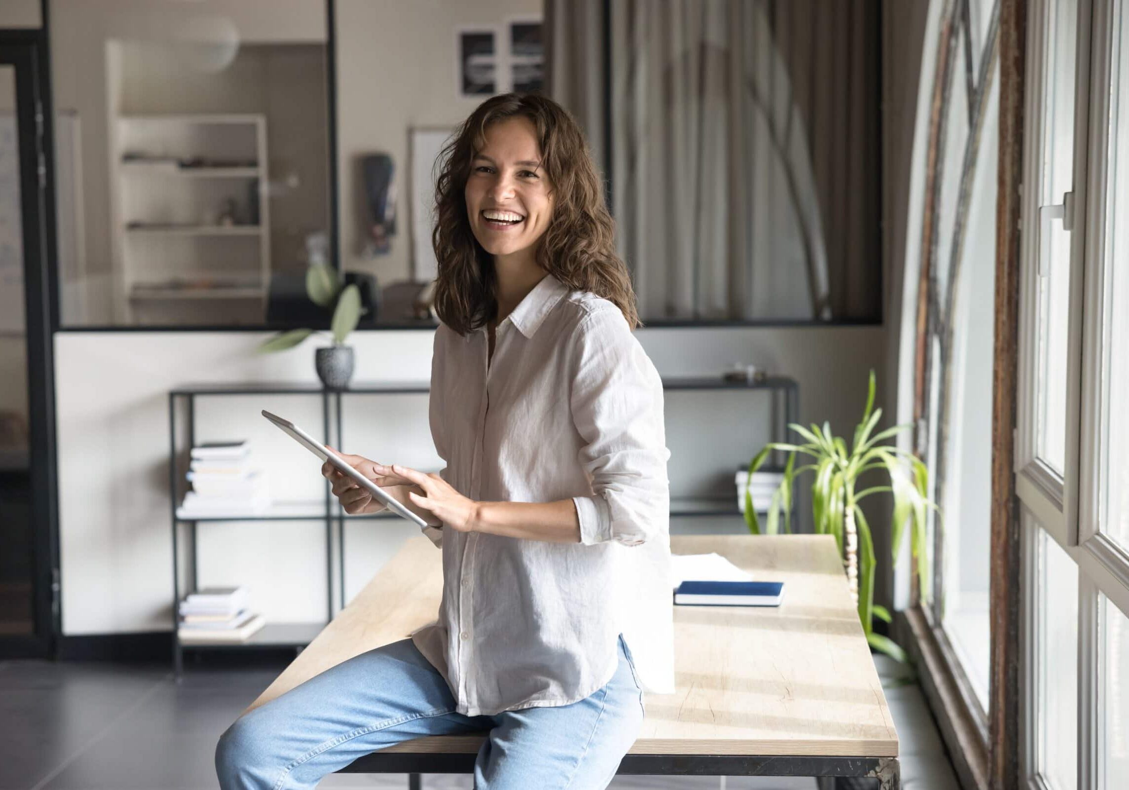 Happy,Successful,Businesswoman,Working,On,Tablet,In,Modern,Workspace,,Receive