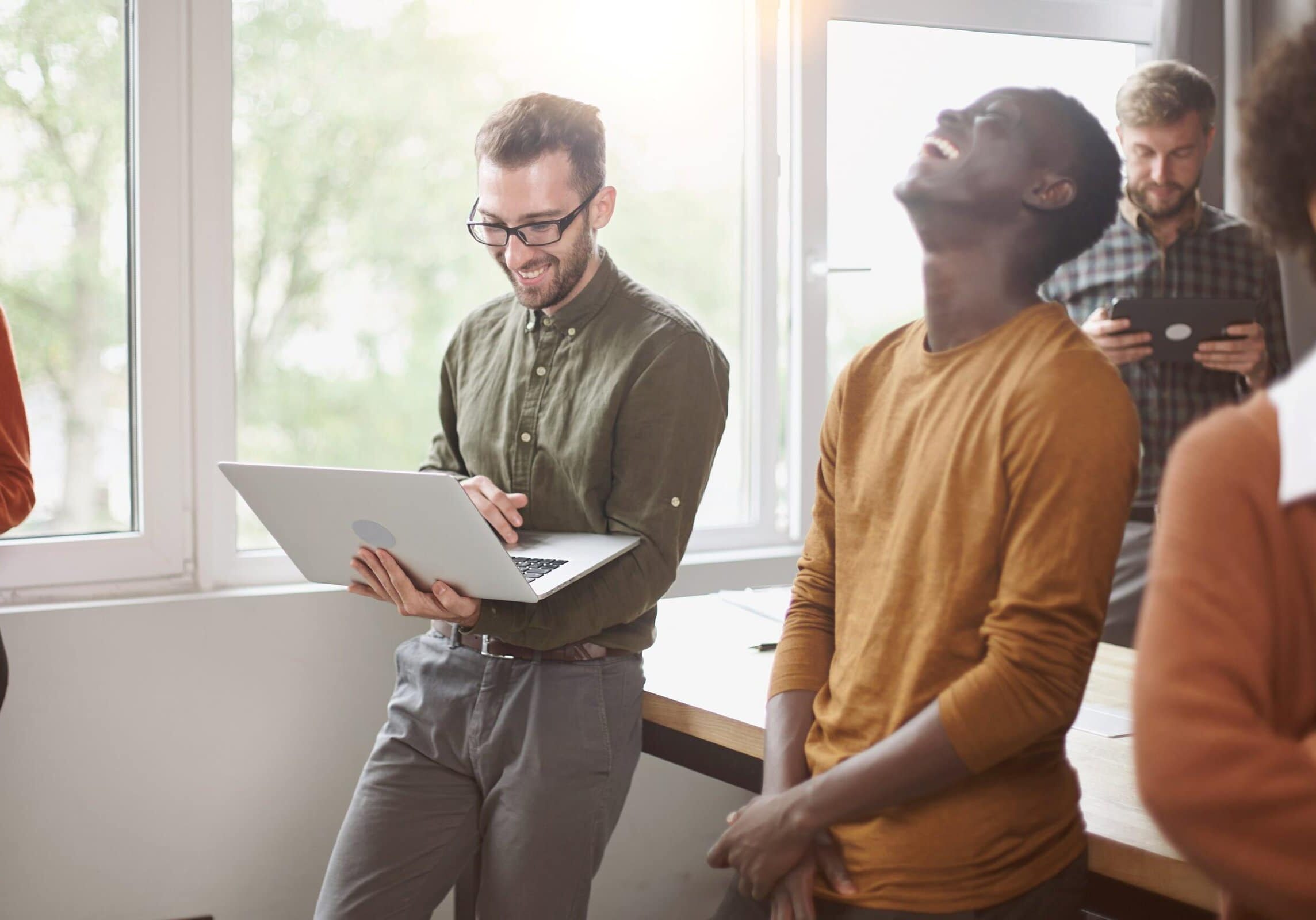 Employees,Standing,Near,A,Table,In,A,Coworking,Center,.