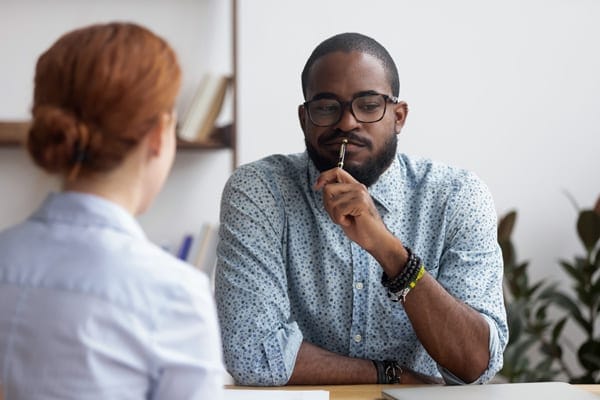 coach client dissonance, two people at a table not agreeing during a conversation