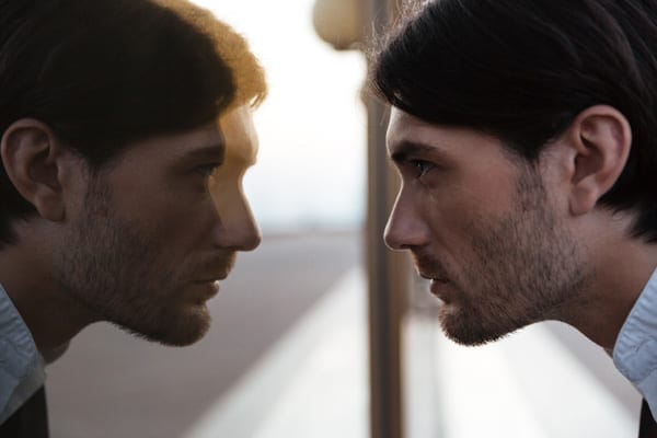 man looking at reflection in a mirror